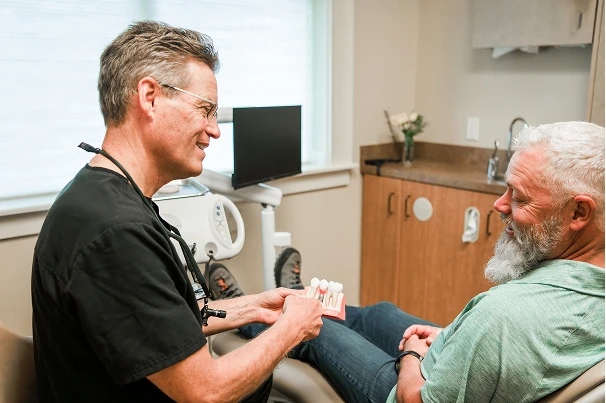 Dr. Johnson showing a teeth model to a patient