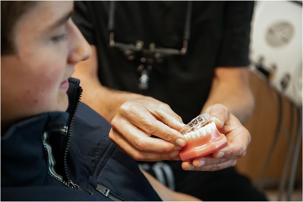 Dr. Johnson showign a patient a teeth model
