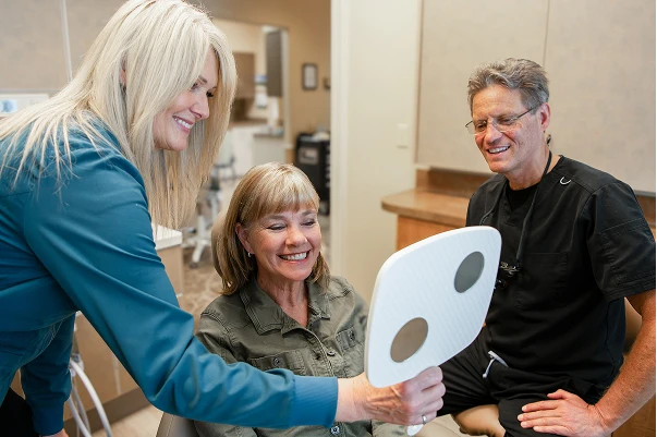 Dr. Johnson showing a patient their new teeth