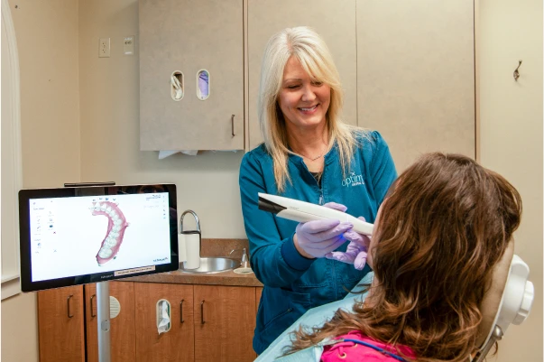 An employee scanning a patient's teeth