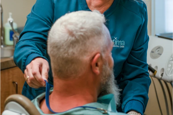 Dr. Johnson putting a bib on a patient